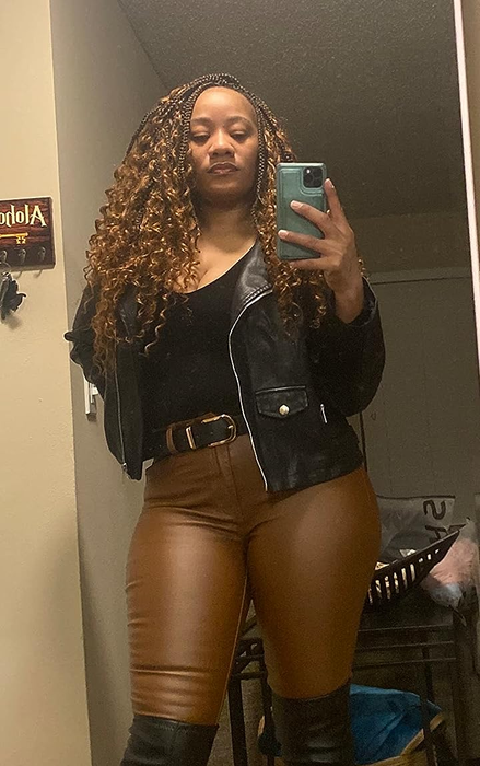 A reviewer is styled in the black jacket with brown leather pants.