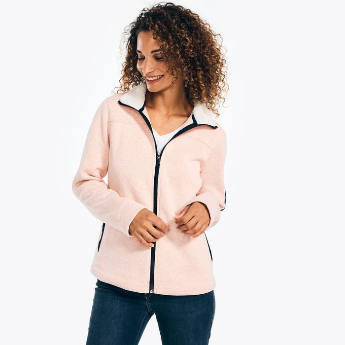 Model showing off the pink jacket with black accents and white fleece lining around the mock neck