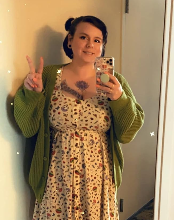 A reviewer is styled in the green cardigan.