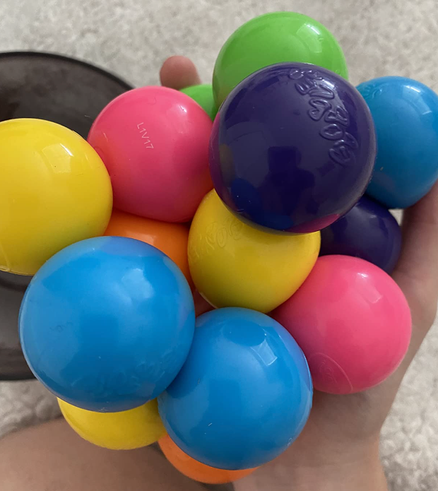 A reviewer holding a set of Globbles in their hand, which stick together into a clump.