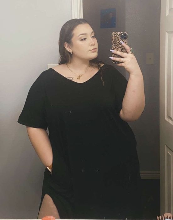 A reviewer wears a sleek black dress.