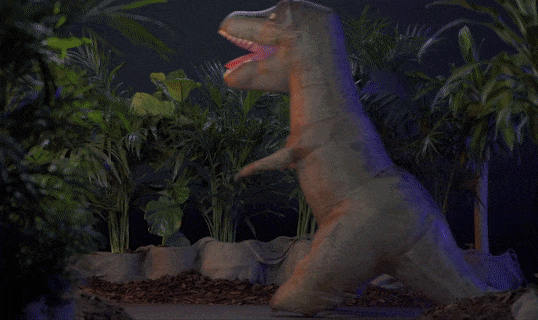 A gif showing a child controlling the inflatable dinosaur with a remote