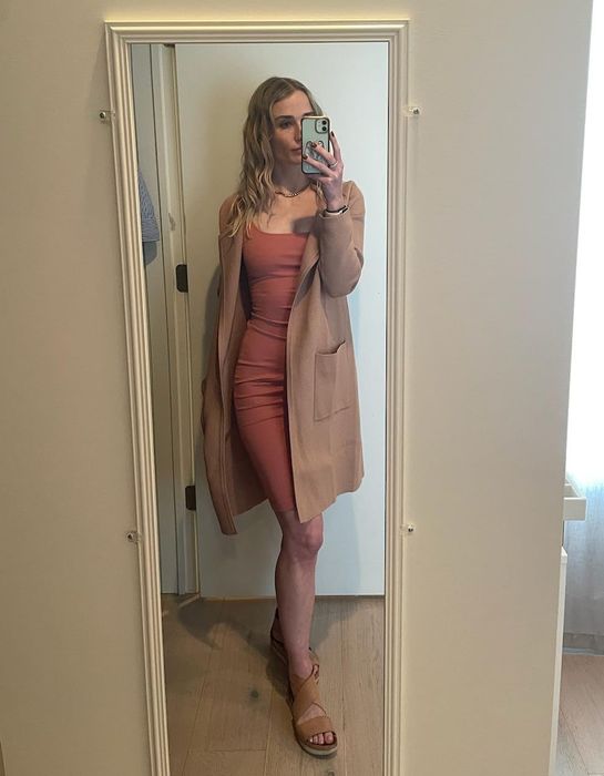 Reviewer showcasing the beige-toned cardigan paired with a dress