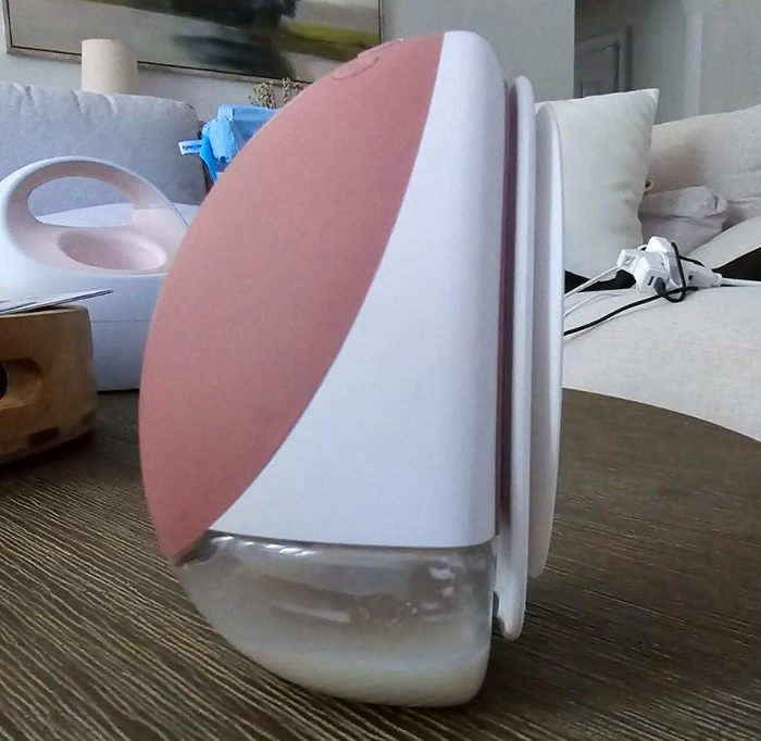 A sleek breast pump in white and pink