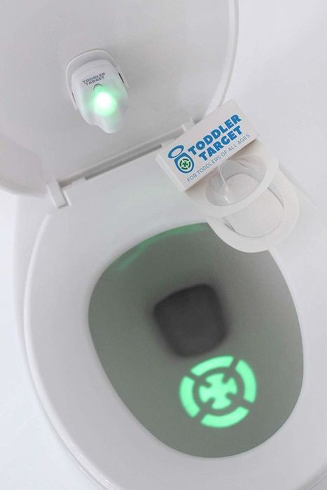 A toilet tank with a target light shining in the water.