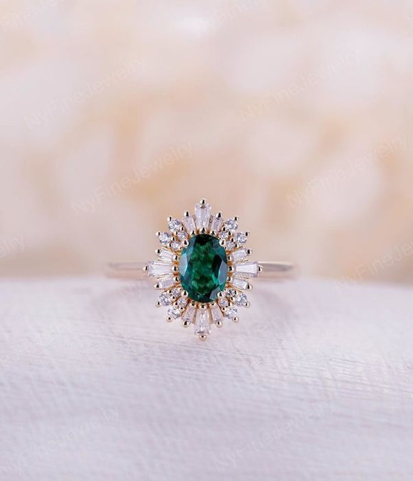 A round emerald encircled by baguette-cut stones, creating a striking, unified piece of elegance.