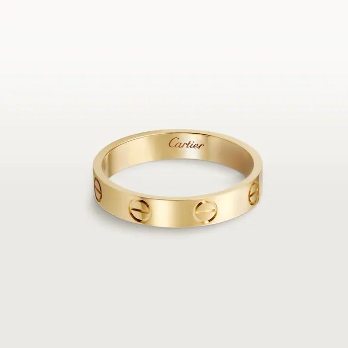 A gold Cartier love band ring