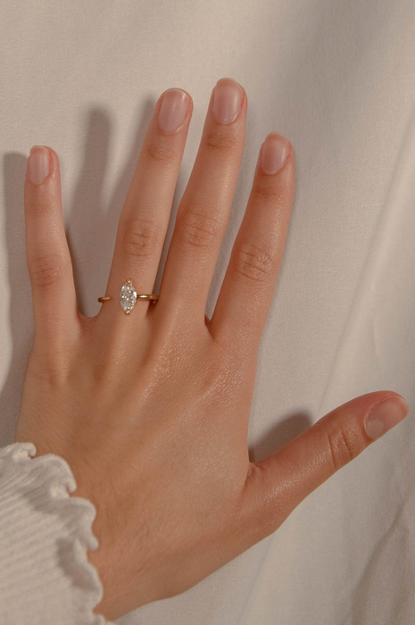 a model showcasing a Marquise diamond on a band with an open design