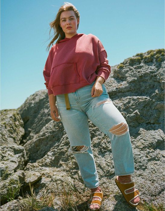 Model rocking ripped blue jeans