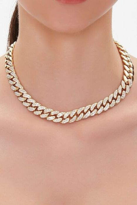 A model styled with a bold Cuban link chain necklace.