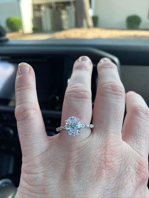 A reviewer showcasing the oval diamond ring with a twisted diamond band