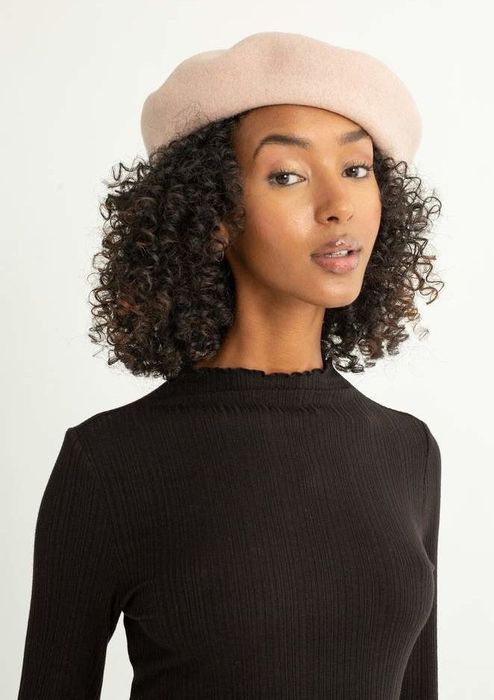 A model showcasing a beige beret