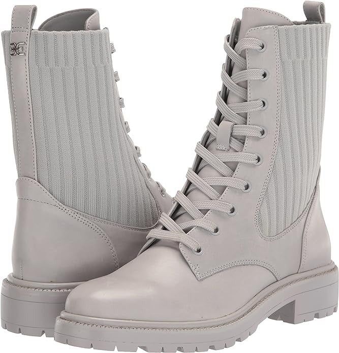 A pair of white lace-up boots with ribbed side panels.