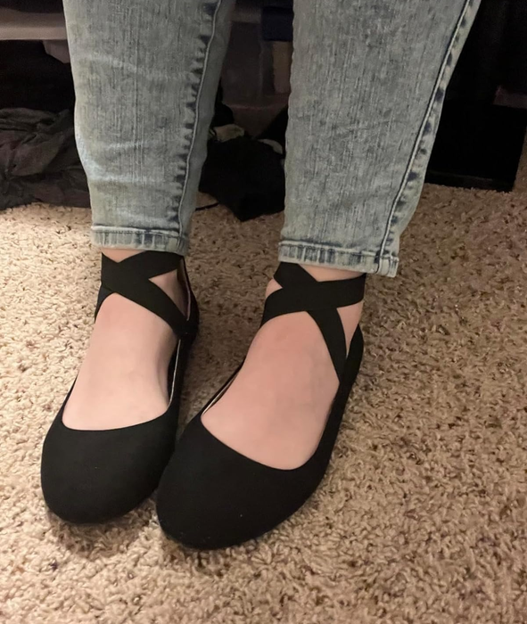 Reviewer showing off black strappy flats.