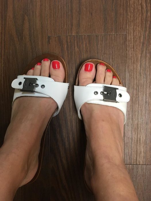 A reviewer modeling white footwear