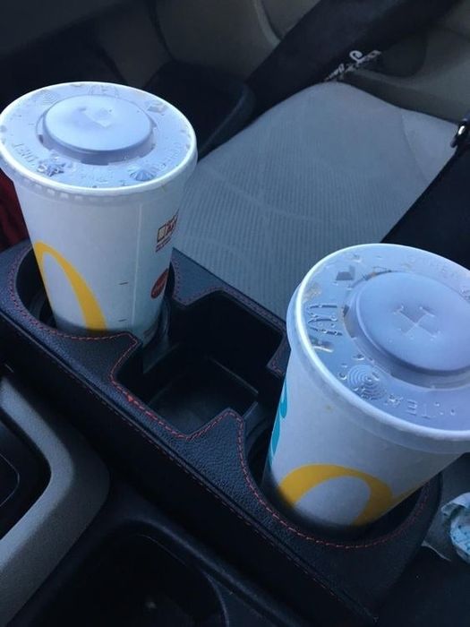 A reviewer's photo showing the console organizer holding two McDonald's cups.