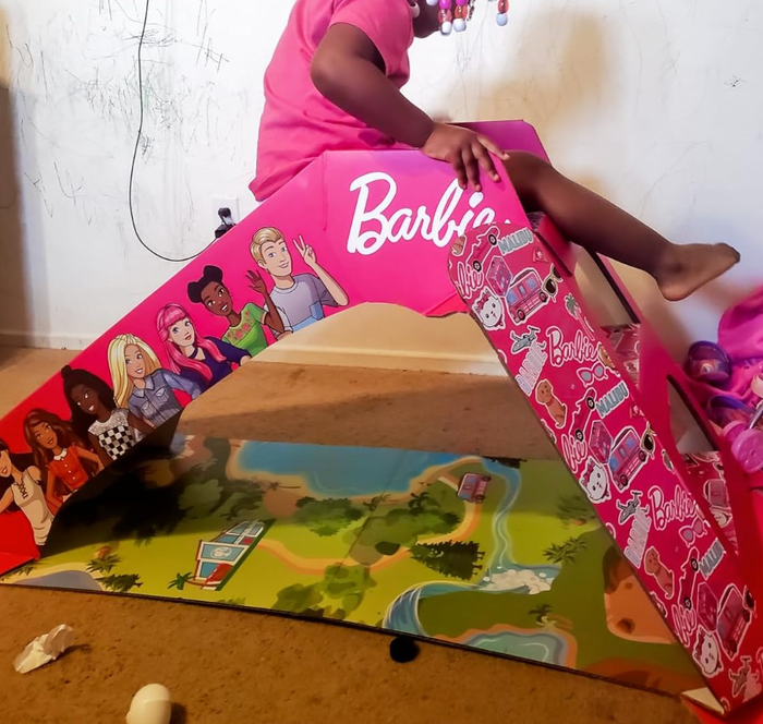 a child enjoying the Barbie cardboard slide