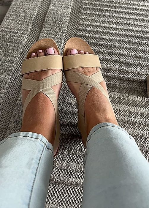 A reviewer showcasing tan-colored sandals