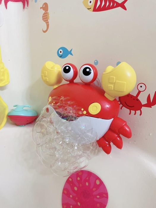 a crab attached to a bathtub wall, releasing a stream of bubbles