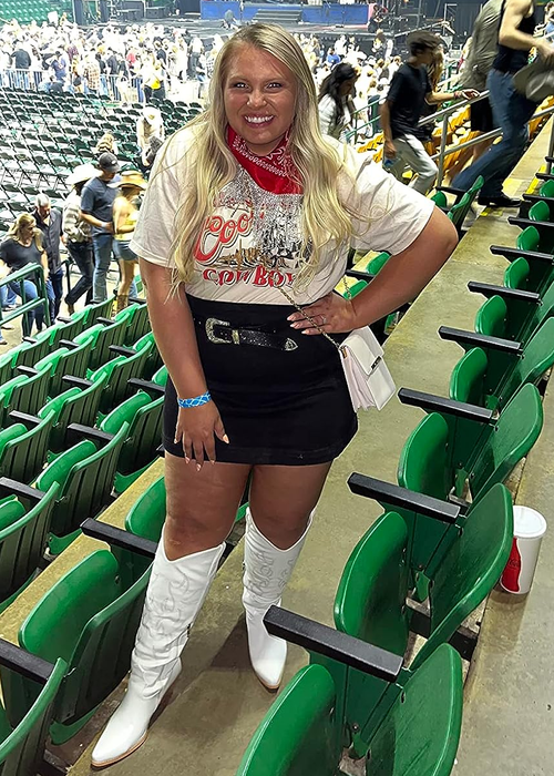 A reviewer wearing the white boots while enjoying a concert.