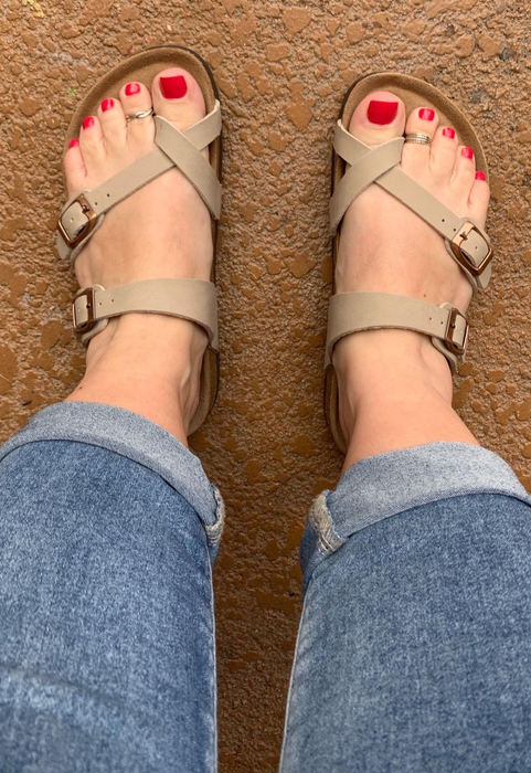 A reviewer wearing the sandals in tan.