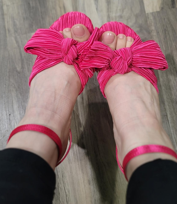 A reviewer shared a photo of themselves wearing the pink bowed heels.