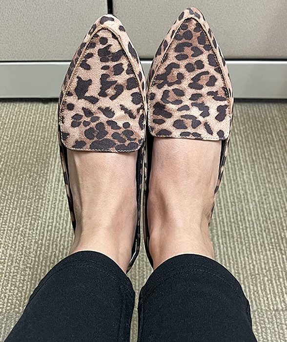 A reviewer wearing a pair of leopard print loafers.