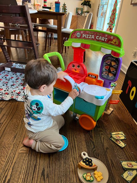 a Mytour editor’s child enjoying playtime with a pizza cart toy