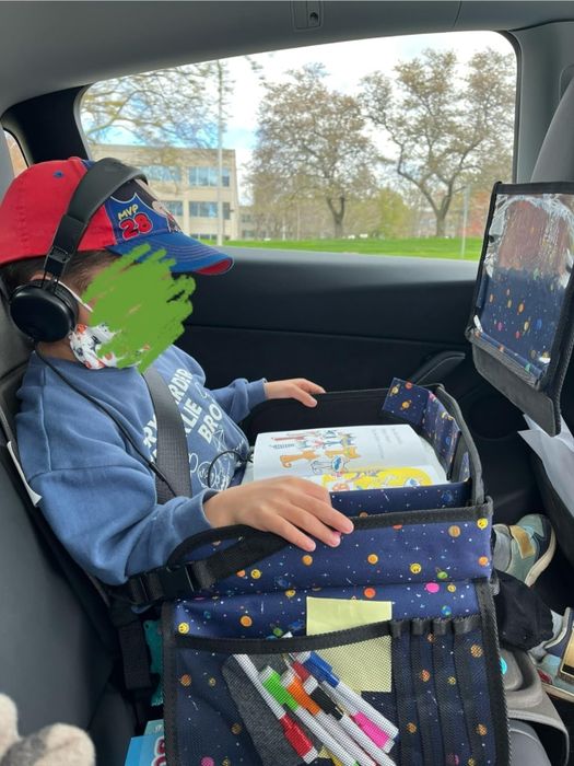 A child using the travel tray in the car.