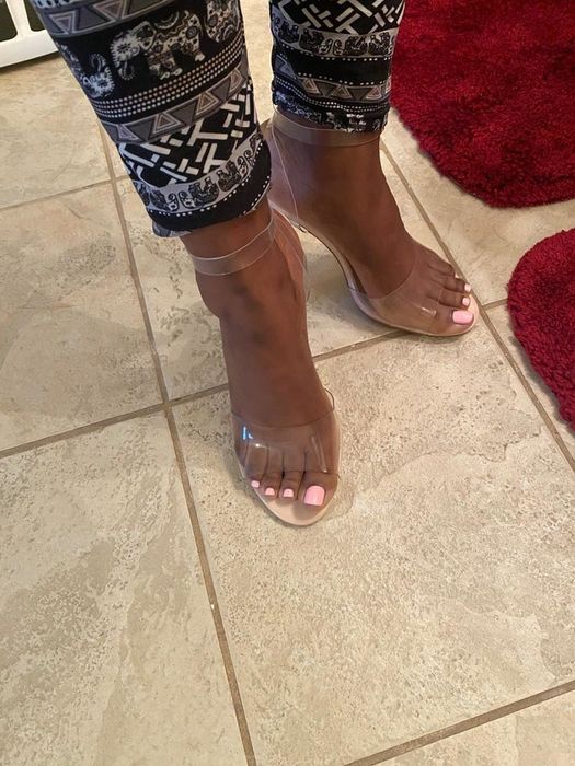 A customer showcasing the stylish clear strappy sandals