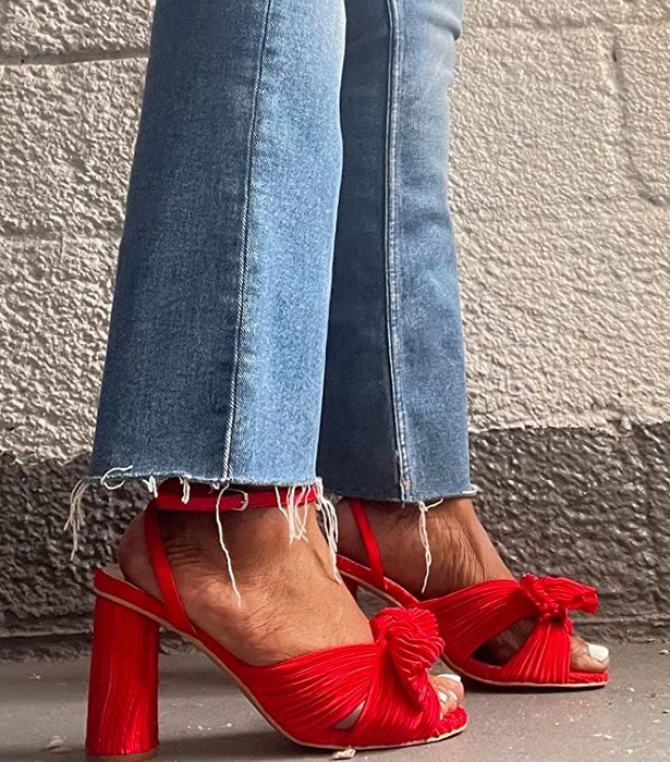 A reviewer showcases the side view of the heels in a bold red color.