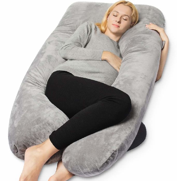 A model comfortably embracing a U-shaped body pillow, showcasing its cozy design.