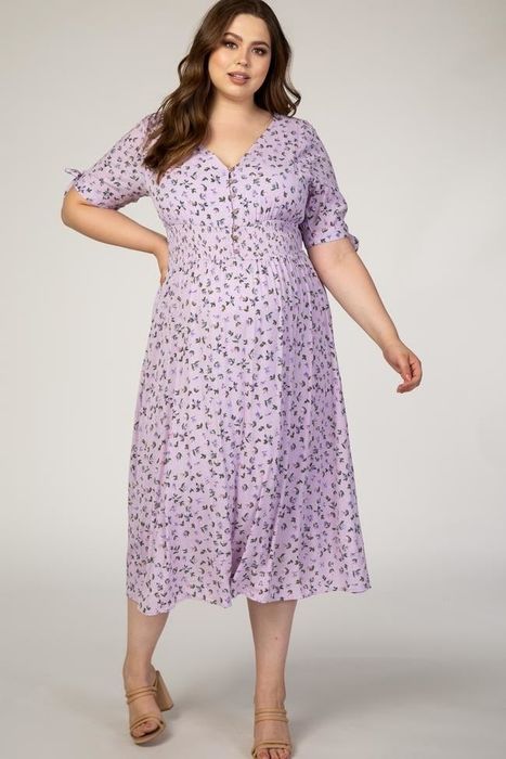 Model with pregnancy belly wearing a midi-length purple floral-print dress featuring short sleeves and a half-button front
