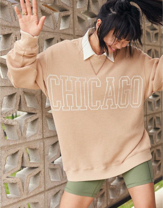 A model styling the sweatshirt in a relaxed yet chic manner.