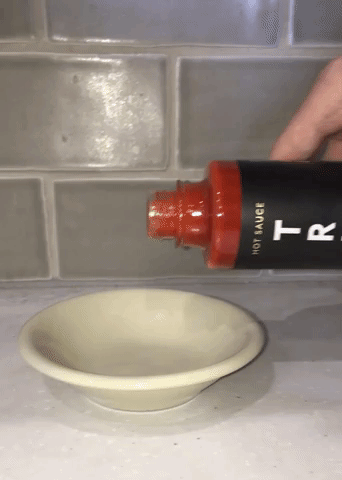 Gif of the writer pouring the Original TRUFF sauce into a dish to showcase its rich consistency and color.