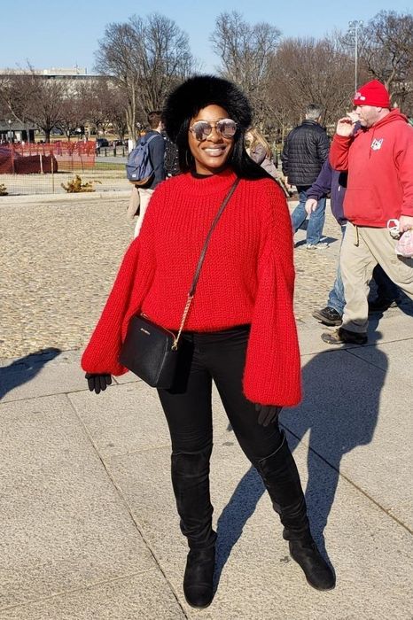 A reviewer styling the sweater in a bold red hue for a vibrant, eye-catching look.