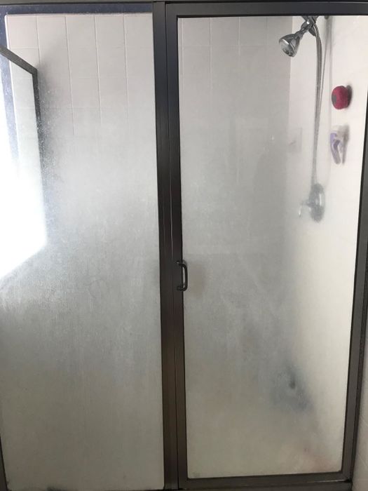 a reviewer's photo of a grimy glass shower door