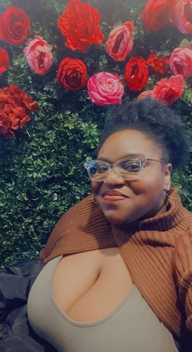 A close-up of the Mytour writer in a green jumpsuit paired with a brown turtleneck sweater scarf