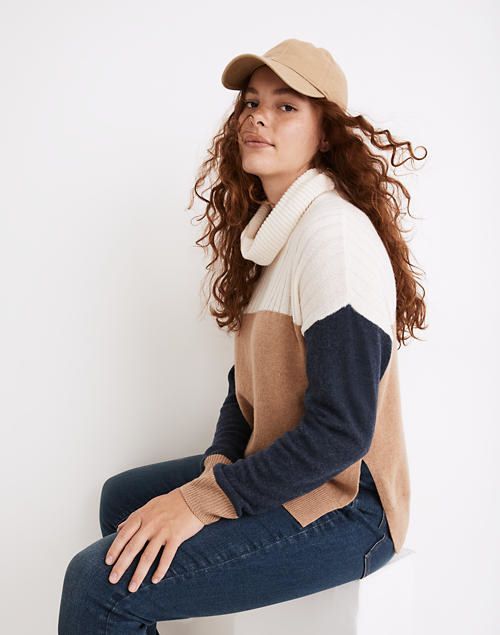 A model showcasing the brown, white, and navy color-blocked sweater