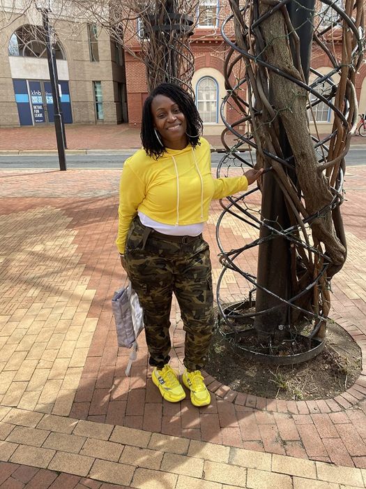 A reviewer shows off their yellow cropped hoodie in an outdoor photo.