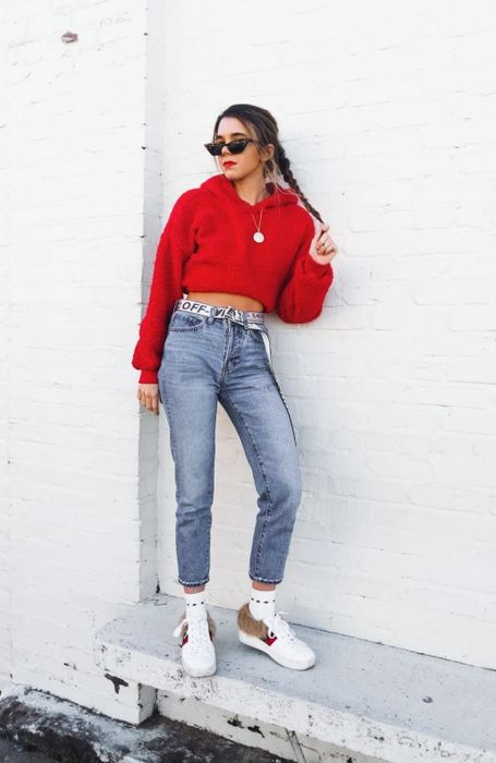 a reviewer in a red hoodie, striking a pose against a white wall