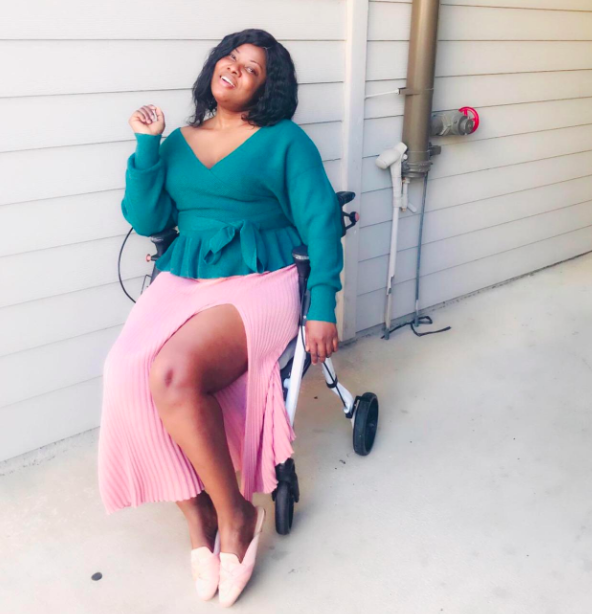 A reviewer rocking the sweater in the green hue
