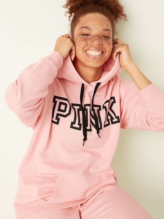 a model wearing a light pink hoodie with the word