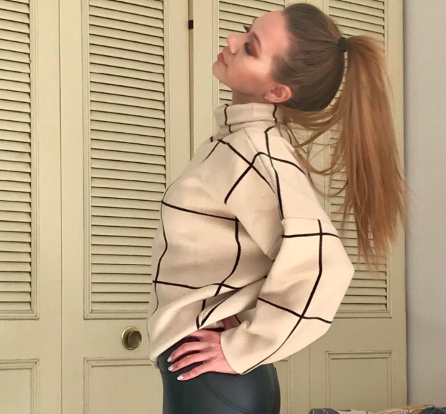 A reviewer rocking the cream turtleneck sweater paired with black leggings