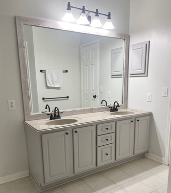 the same reviewer's vanity after applying the cabinet paint, now appearing modern and revitalizing the space