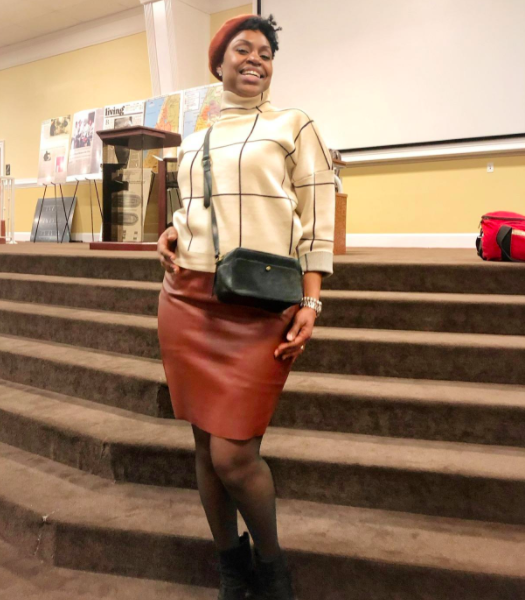 A reviewer styling the cream turtleneck sweater with a chic pencil skirt