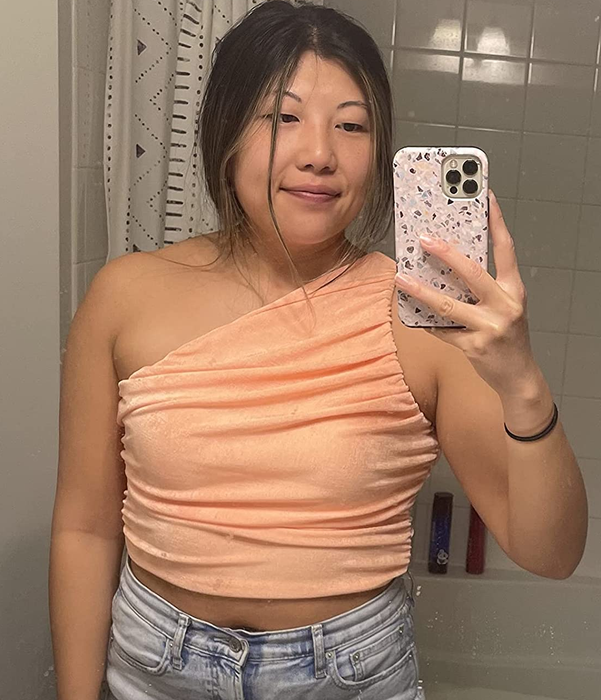 A reviewer shown wearing the peach top