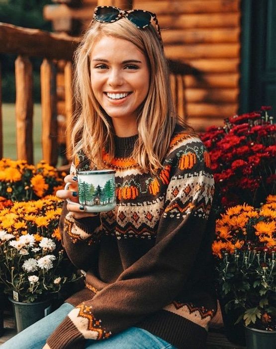 A model wearing a brown Sea Isle sweater adorned with a pumpkin design.