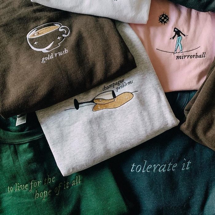 a pile of embroidered Taylor Swift sweatshirts