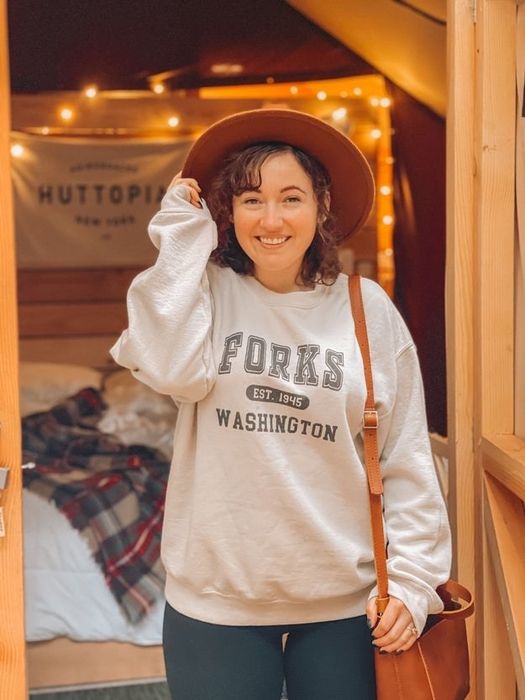 The staff writer is rocking a cream-colored sweatshirt that reads